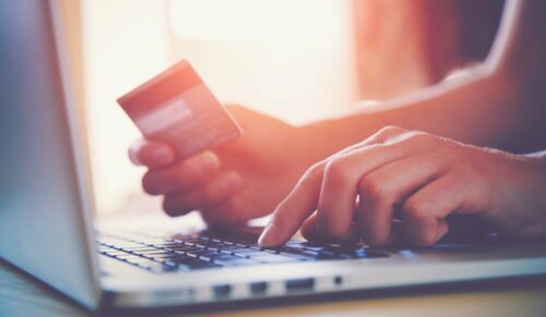 Hands holding credit card and using laptop. Online shopping