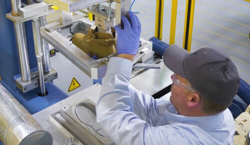 Ein BASF-Mitarbeiter nimmt an GUSBI-Maschine einen Schuh aus der Form. (Foto: BASF)