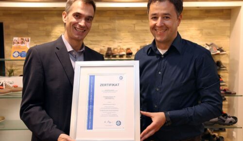 Der Bereichsleiter Marketing der ANWR Schuh GmbH, Michael Fischer (l.), und der Leiter des Schuhhauses Enners, Kai Enners, posieren am Freitag (11.07.14) im Schuhhaus Enners in Bad Marienberg mit einem TÜV-Zertifikat.